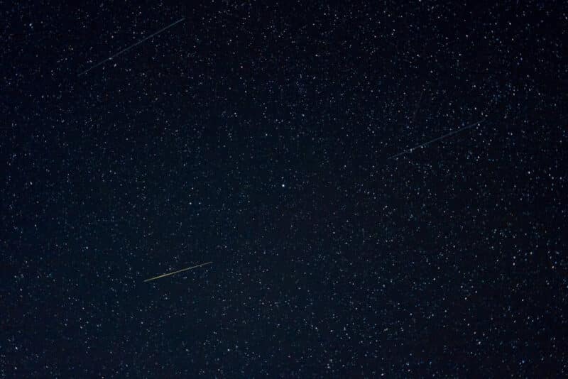Geminids meteor shower black sky with stars, including streaking meteors