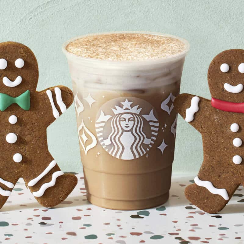 Iced Gingerbread Oatmilk Chai in Starbucks cup surrounded by gingerbread cookies