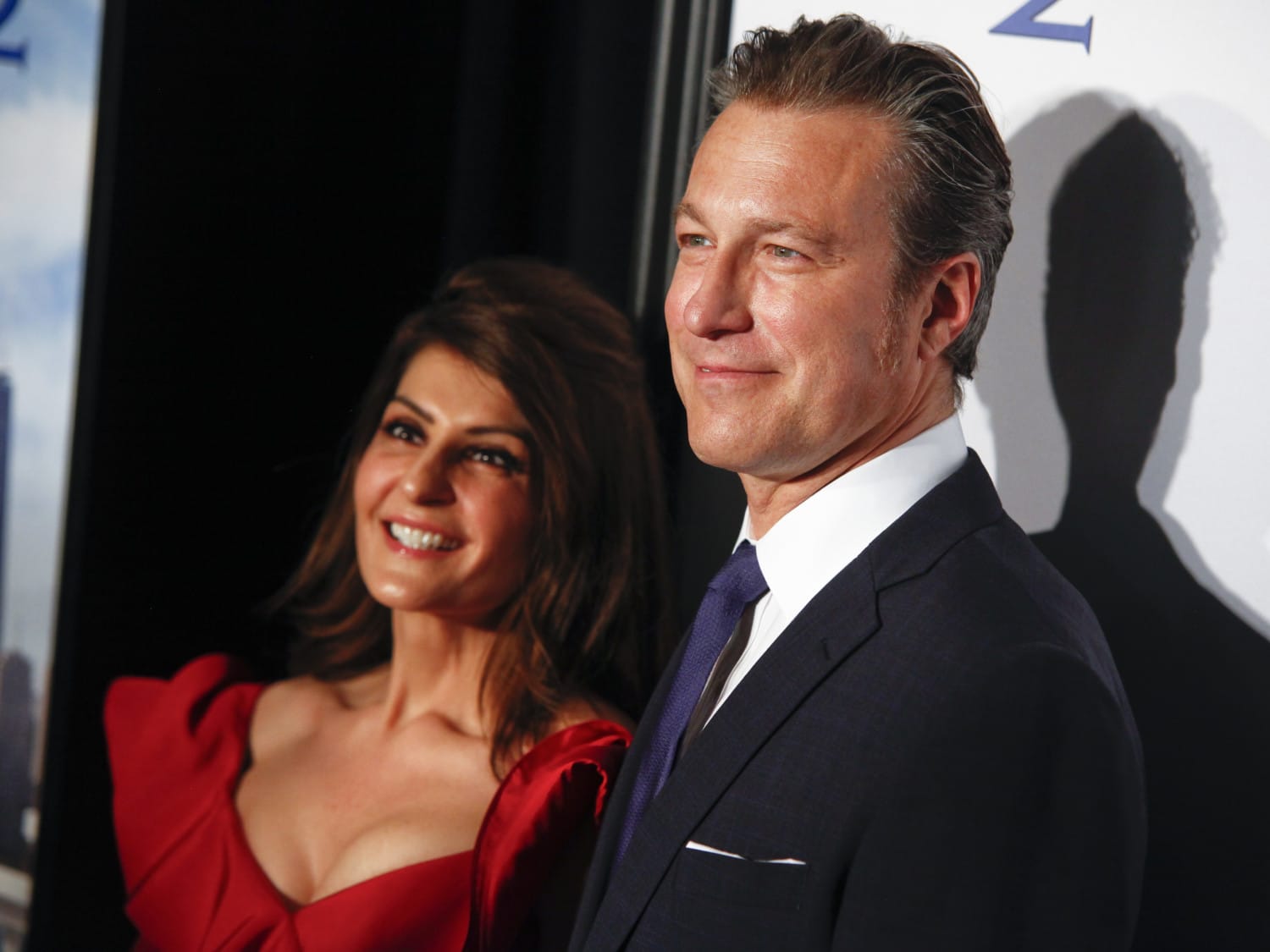 Nia Vardalos and John Corbett stand at red carpet event