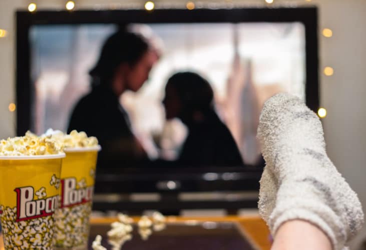 Young woman watching watching a movie with popcorn.