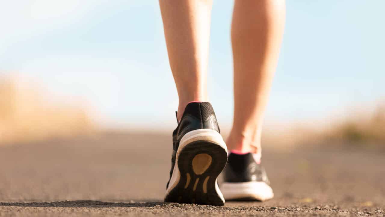 A person walks in walking shoes on a flat surface.