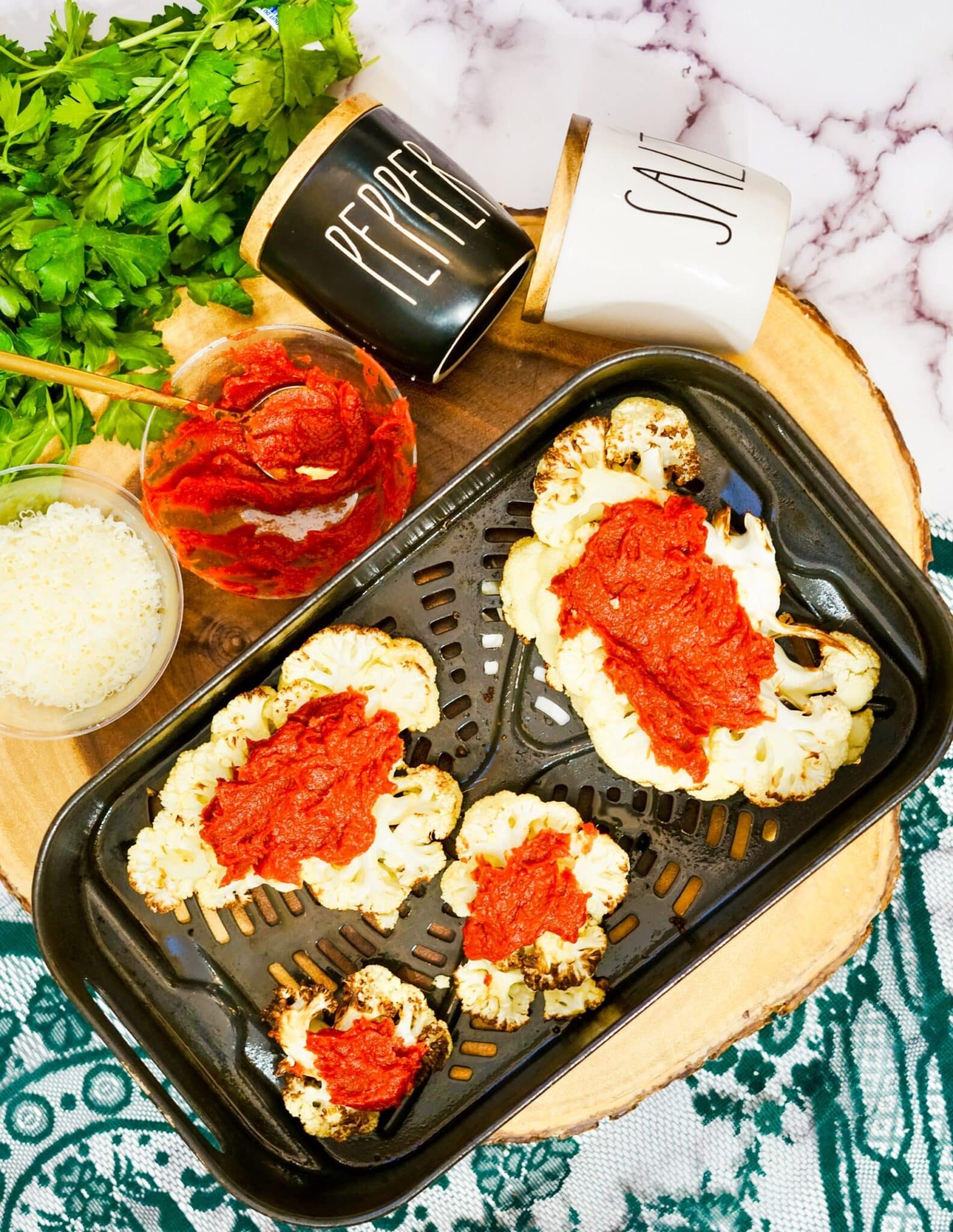 Air fryer cauliflower parmesan in an air fryer basket.