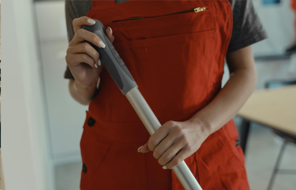 Cleaning worker holding mop.