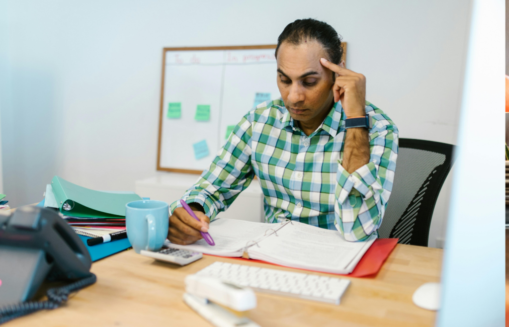 A stressed worker surrounded by tasks