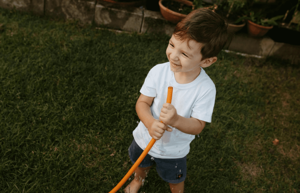 kid drinking from hose