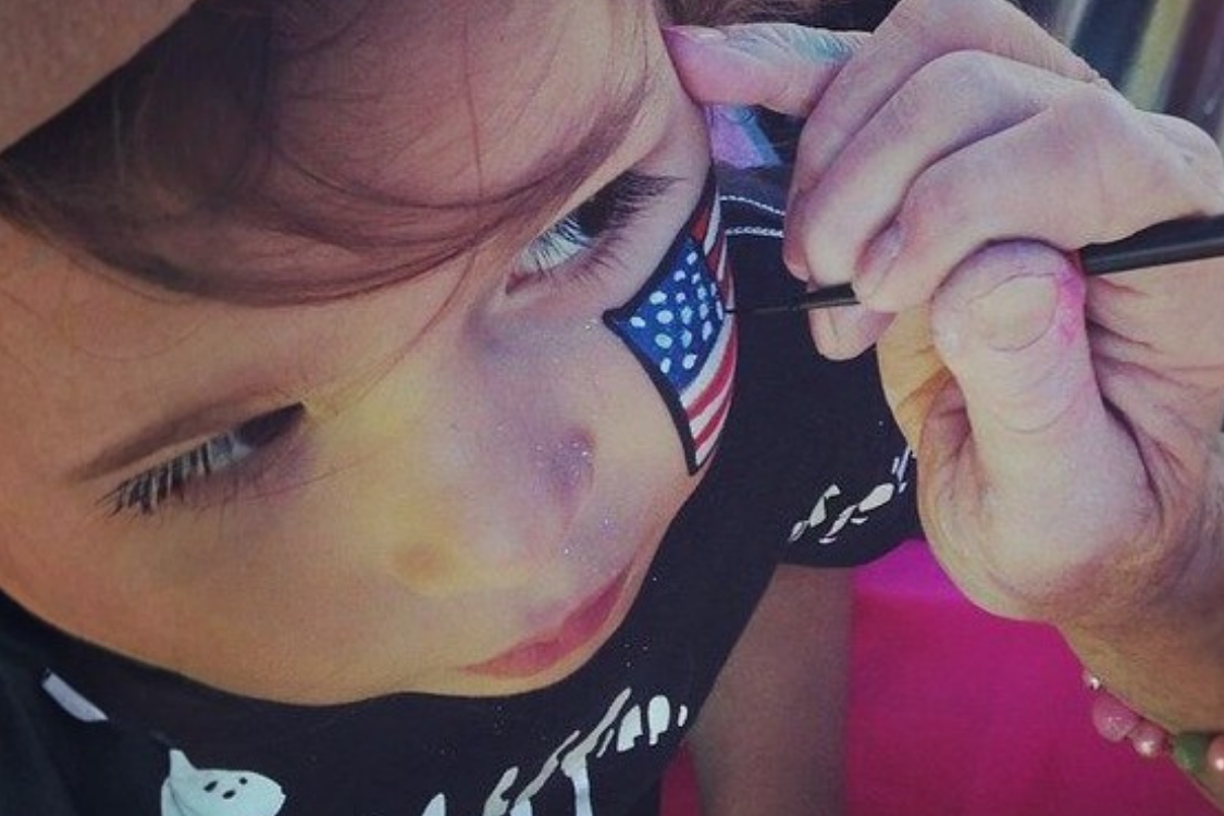 Kid with a patriotic face paint for 4th of July