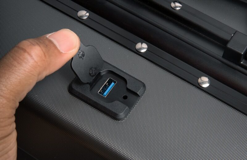 a hand is pressing a button on a piece of luggage