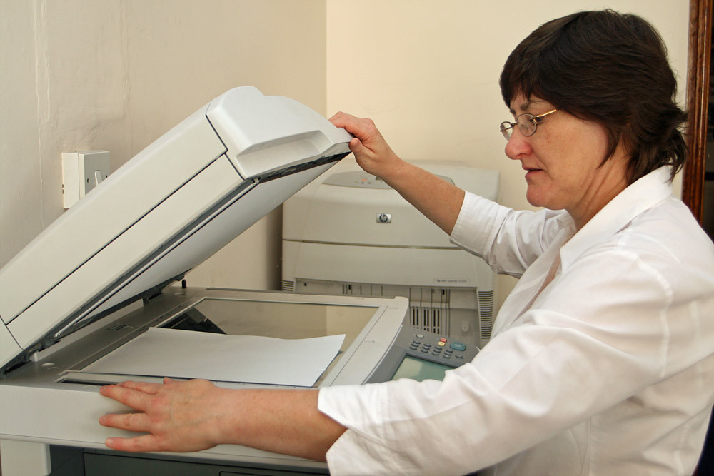 Woman using photocopier for school worksheets