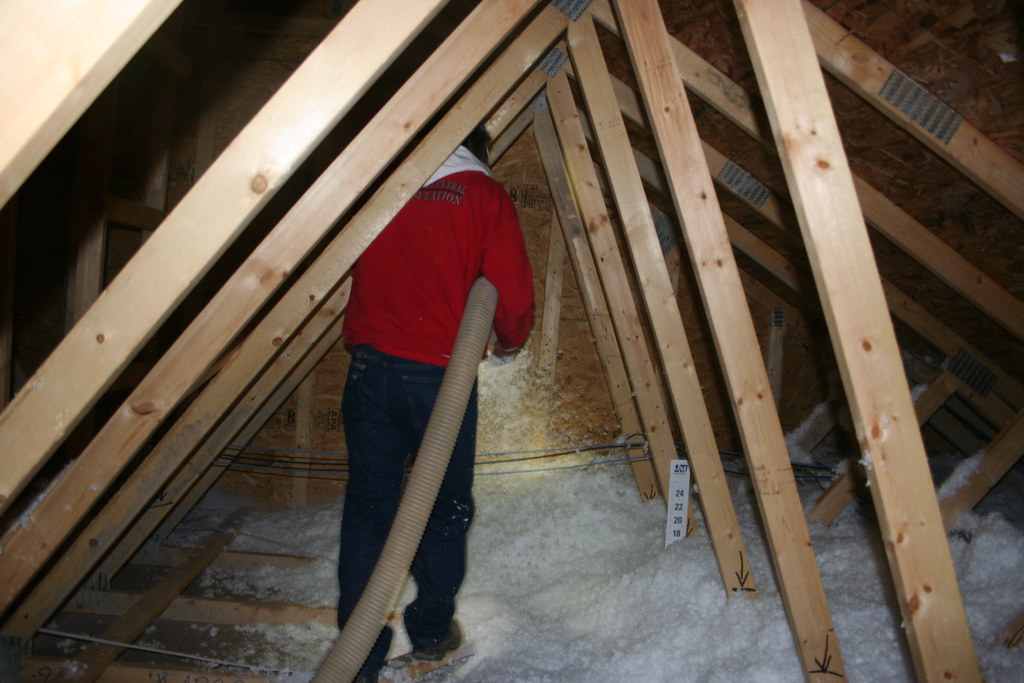 Worker installing insulation in an attic